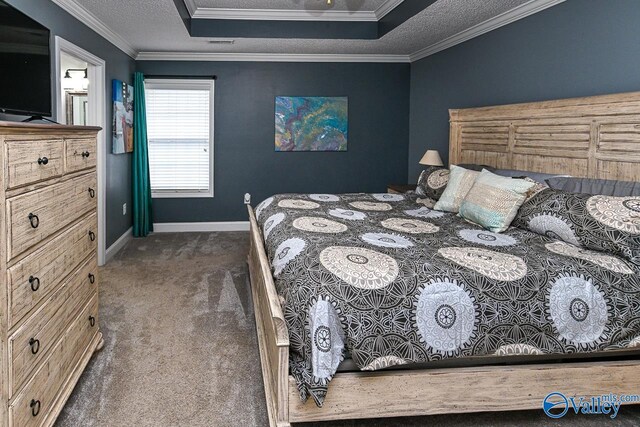 bedroom featuring dark colored carpet, a raised ceiling, ornamental molding, and a textured ceiling