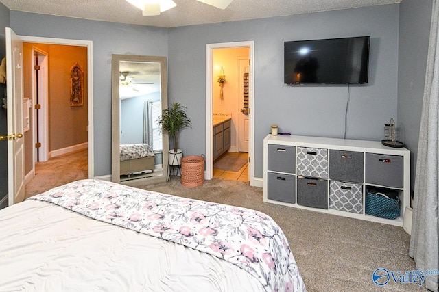 carpeted bedroom with a textured ceiling, ensuite bath, and ceiling fan