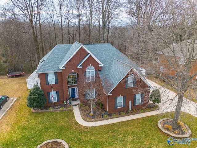 view of front of home with a trampoline and a front lawn