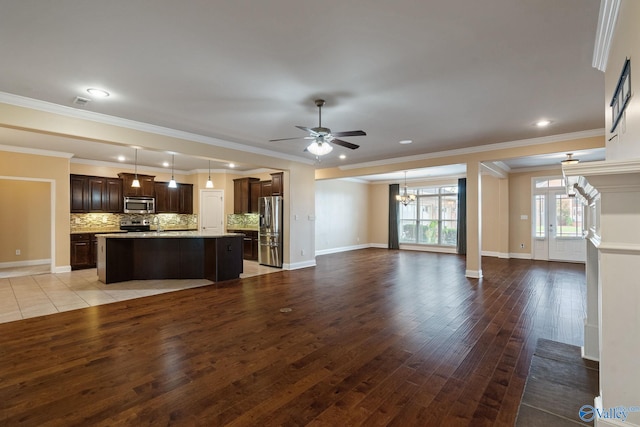 unfurnished living room featuring light wood-type flooring, ornamental molding, and ceiling fan with notable chandelier