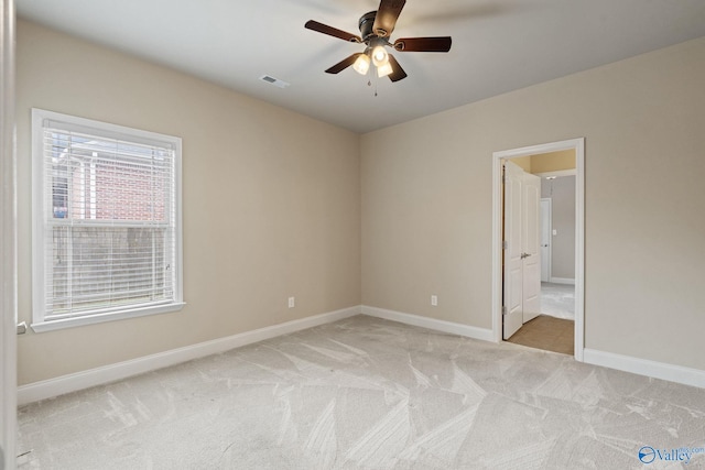 spare room featuring light colored carpet and ceiling fan