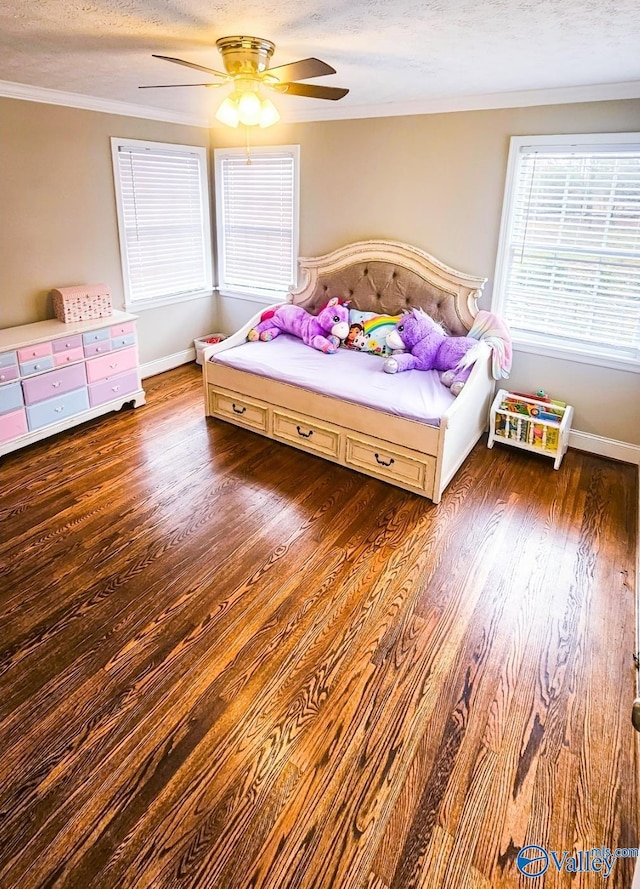 bedroom with dark hardwood / wood-style flooring, ceiling fan, ornamental molding, and a textured ceiling