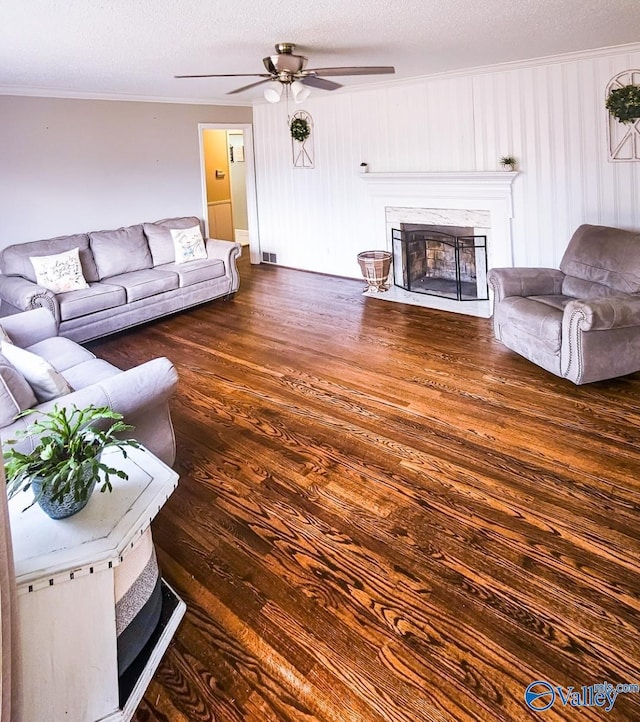 living room with ornamental molding, ceiling fan, a textured ceiling, and dark hardwood / wood-style flooring