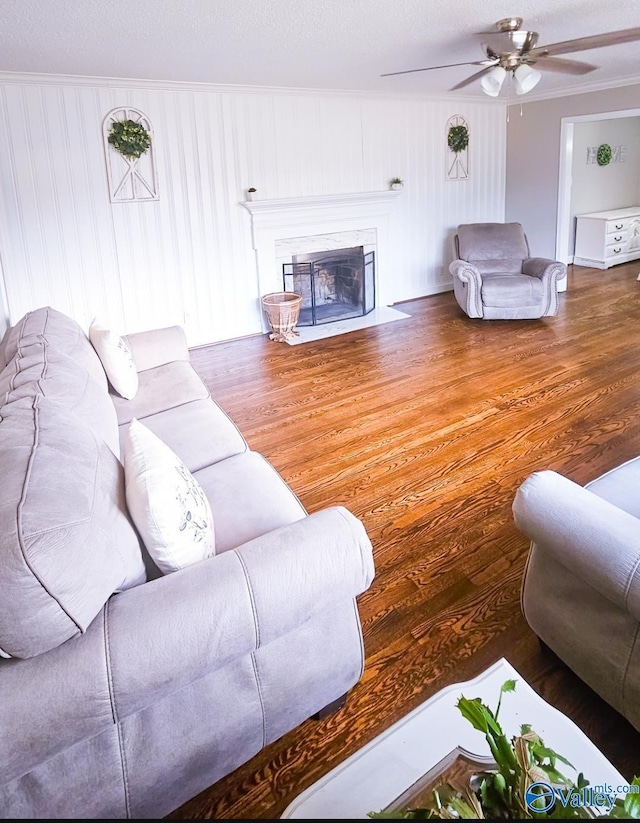 living room with wood-type flooring, ceiling fan, and crown molding