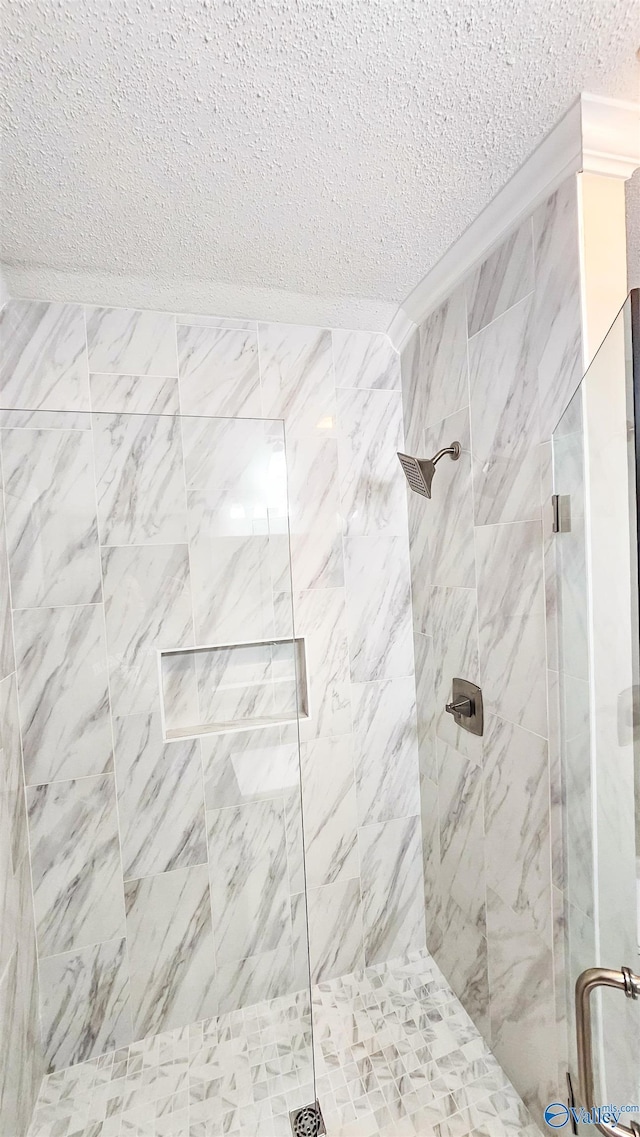 bathroom with a shower with door and a textured ceiling