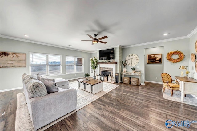 living room featuring ceiling fan, dark hardwood / wood-style flooring, ornamental molding, and a fireplace