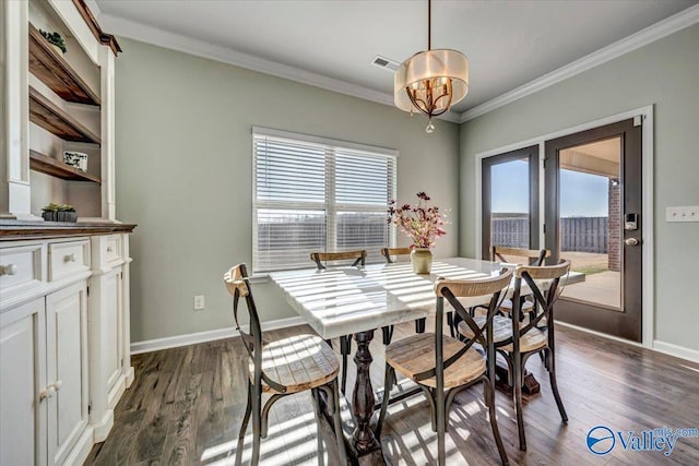 dining space with dark wood-type flooring, a healthy amount of sunlight, and ornamental molding