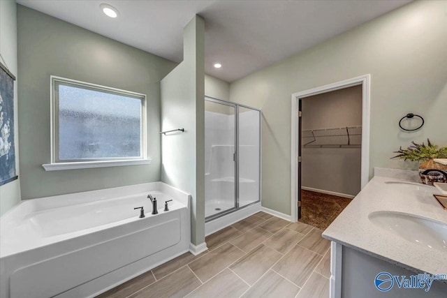 bathroom featuring shower with separate bathtub and vanity