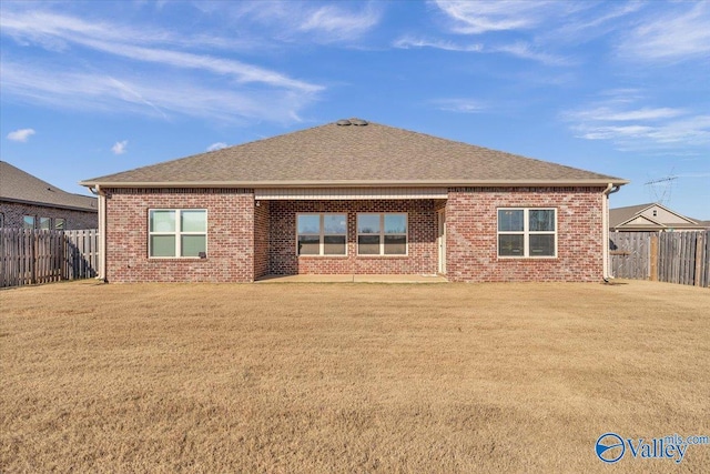 rear view of property featuring a lawn