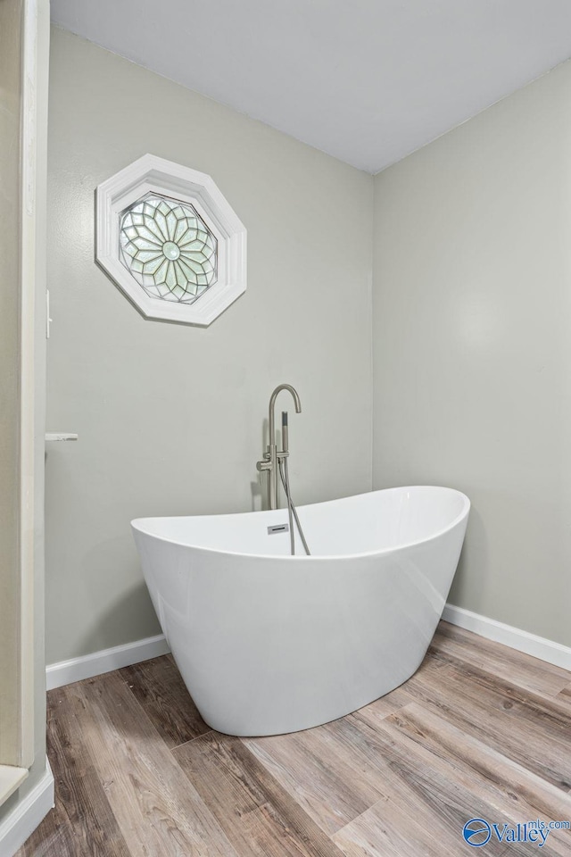 bathroom featuring a tub to relax in and hardwood / wood-style floors