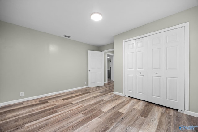 unfurnished bedroom featuring a closet and hardwood / wood-style flooring