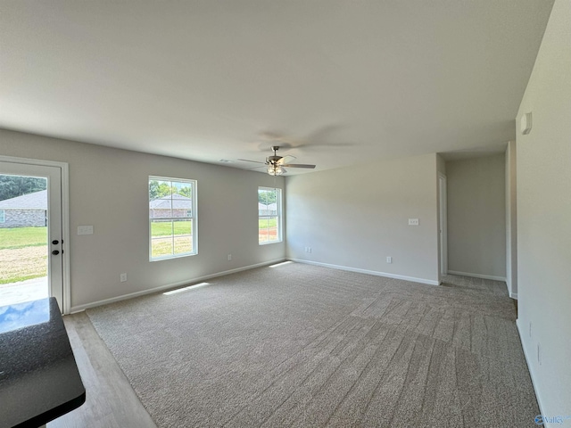 carpeted spare room with ceiling fan