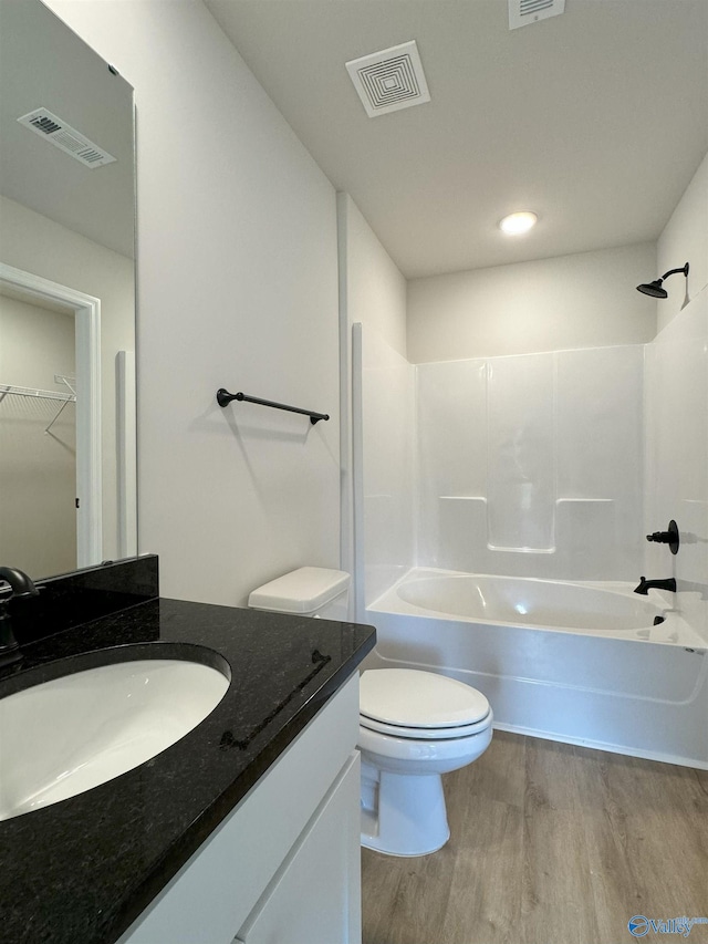 full bathroom with vanity, hardwood / wood-style floors, toilet, and washtub / shower combination