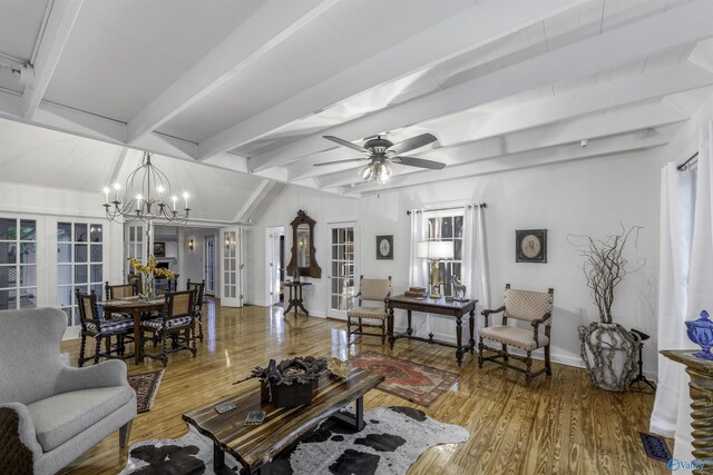 living room featuring lofted ceiling with beams, ceiling fan with notable chandelier, french doors, and light wood-type flooring