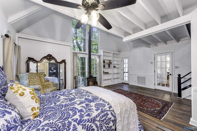 bedroom with ceiling fan, hardwood / wood-style floors, beamed ceiling, a barn door, and a towering ceiling