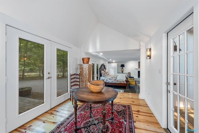 sitting room featuring light hardwood / wood-style flooring, lofted ceiling, and french doors