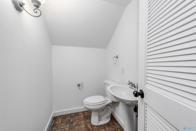 bathroom featuring tile patterned flooring, vaulted ceiling, and toilet