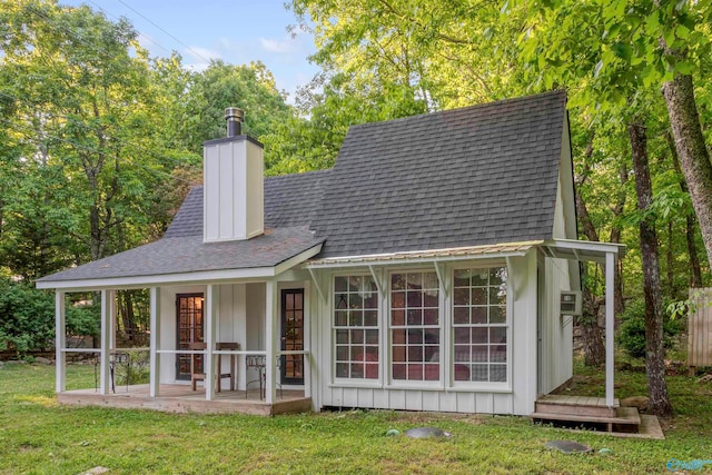 rear view of property featuring a lawn