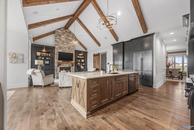 27 Watson Grande Way, Owens Cross Roads, AL 35763 - kitchen with stainless steel appliances, dark wood-style flooring, a sink, open floor plan, and a fireplace