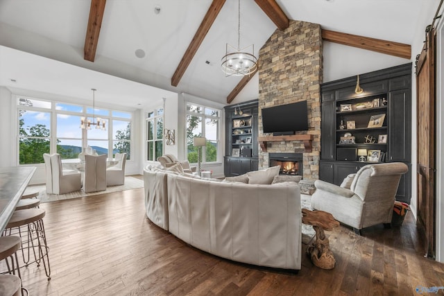 27 Watson Grande Way, Owens Cross Roads, AL 35763 - living area featuring a chandelier, dark wood-style floors, a stone fireplace, and healthy amount of natural light