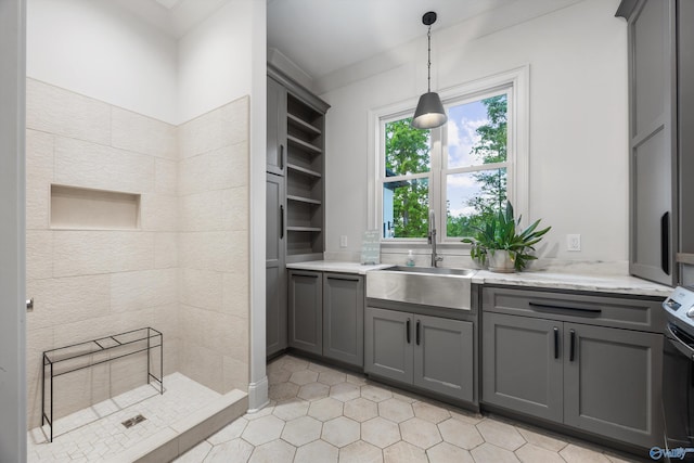 27 Watson Grande Way, Owens Cross Roads, AL 35763 - kitchen with a sink, gray cabinetry, open shelves, light tile patterned floors, and hanging light fixtures