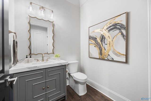 27 Watson Grande Way, Owens Cross Roads, AL 35763 - half bathroom featuring wood finished floors, toilet, baseboards, vanity, and crown molding