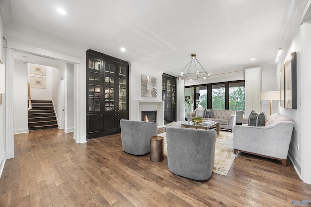 27 Watson Grande Way, Owens Cross Roads, AL 35763 - living area with stairway, hardwood / wood-style floors, a lit fireplace, crown molding, and recessed lighting