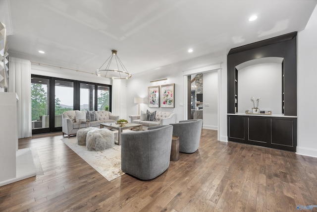 27 Watson Grande Way, Owens Cross Roads, AL 35763 - living area with dark wood-type flooring, a chandelier, recessed lighting, arched walkways, and baseboards