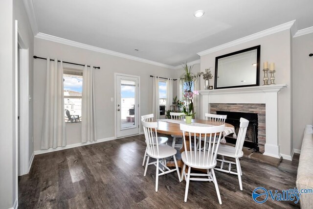 dining room featuring ornamental molding, dark wood-type flooring, and a fireplace