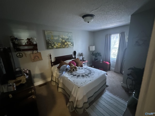 bedroom featuring carpet, baseboards, and a textured ceiling