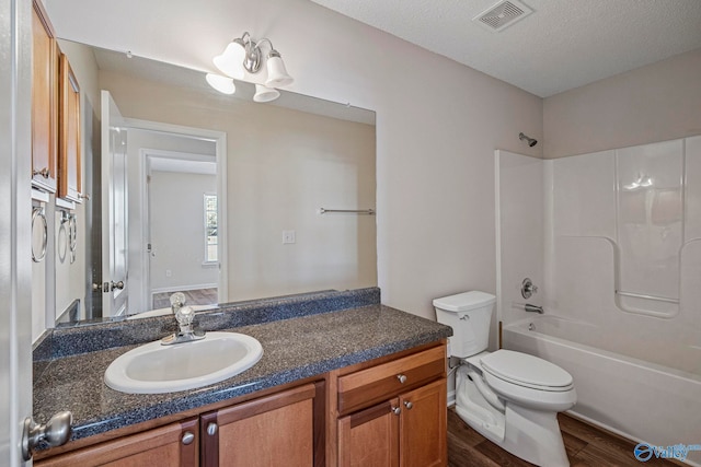 full bath featuring visible vents, toilet, wood finished floors,  shower combination, and vanity