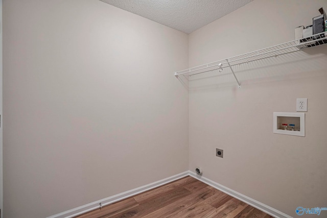 laundry room with electric dryer hookup, washer hookup, wood finished floors, baseboards, and laundry area