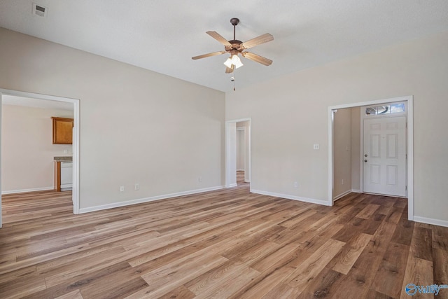 interior space with light wood finished floors, visible vents, baseboards, and ceiling fan