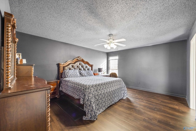 bedroom with ceiling fan, dark hardwood / wood-style flooring, and a textured ceiling