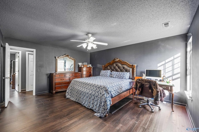 bedroom featuring dark wood-type flooring, ceiling fan, and a textured ceiling