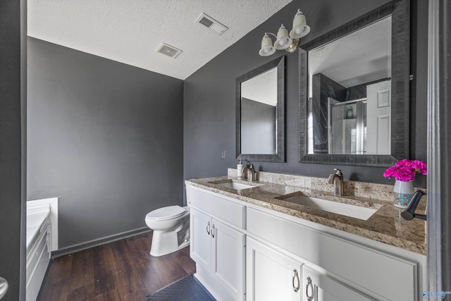 full bathroom featuring hardwood / wood-style flooring, vanity, a textured ceiling, shower with separate bathtub, and toilet