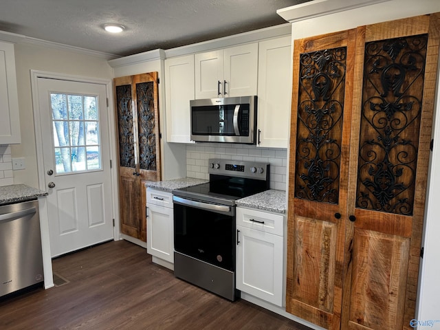 kitchen with white cabinets, dark hardwood / wood-style floors, tasteful backsplash, light stone counters, and stainless steel appliances