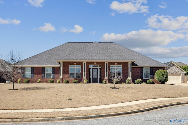 view of front of property featuring a garage, brick siding, and a shingled roof