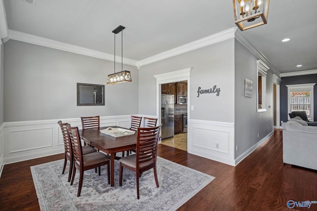 dining area with recessed lighting, a wainscoted wall, crown molding, and wood finished floors