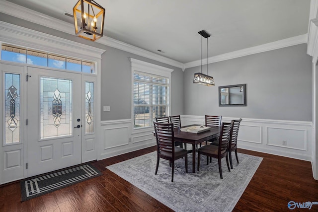 dining space with a wainscoted wall, crown molding, visible vents, and dark wood-type flooring