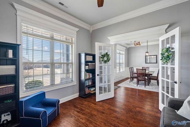 living area with visible vents, ceiling fan, wood finished floors, crown molding, and french doors