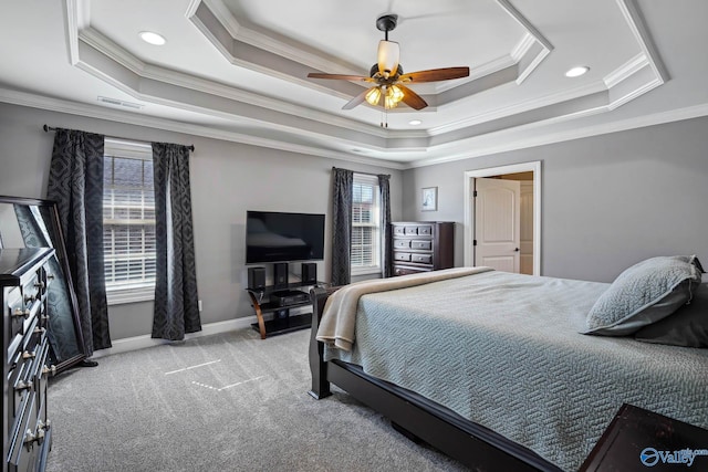 bedroom with ceiling fan, light colored carpet, visible vents, baseboards, and a tray ceiling