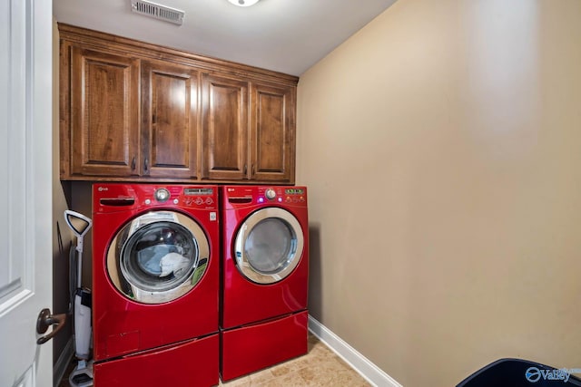 clothes washing area featuring baseboards, cabinet space, visible vents, and washer and dryer