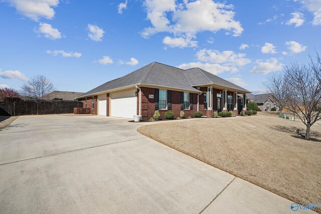 view of front facade with a shingled roof, concrete driveway, an attached garage, fence, and brick siding