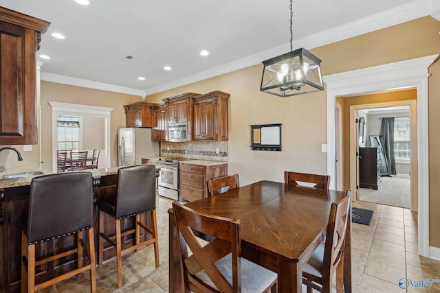 dining space featuring light tile patterned floors, ornamental molding, an inviting chandelier, and recessed lighting