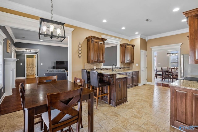 kitchen with a notable chandelier, visible vents, backsplash, a sink, and baseboards