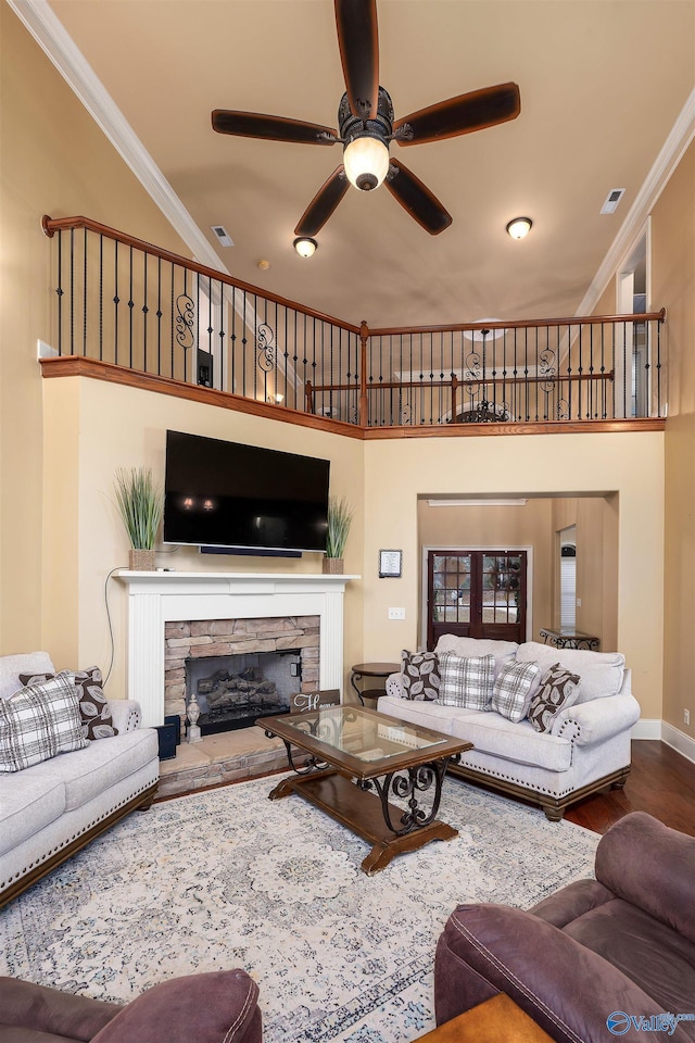 living room featuring crown molding, a fireplace, ceiling fan, and hardwood / wood-style floors