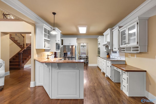 kitchen featuring kitchen peninsula, stainless steel refrigerator with ice dispenser, crown molding, pendant lighting, and white cabinets