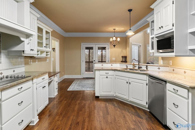 kitchen featuring hanging light fixtures, sink, appliances with stainless steel finishes, white cabinetry, and kitchen peninsula