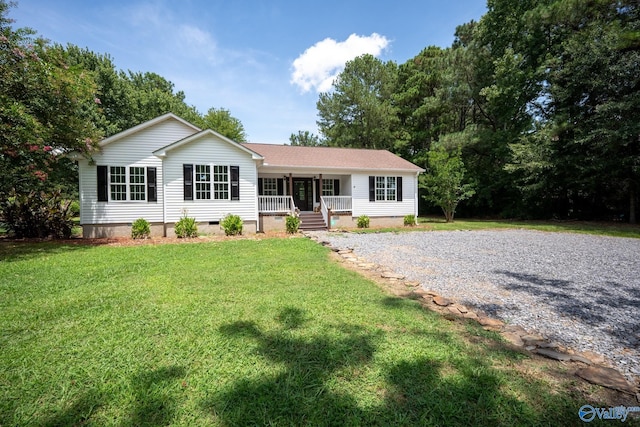 ranch-style house featuring covered porch and a front lawn